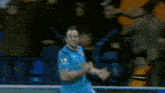 a soccer player in a blue jersey runs past a referee on the field
