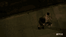 a woman standing on a sidewalk with a netflix logo on the bottom