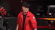 a man in a red jacket giving a thumbs up