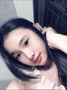 a girl with long black hair is looking at the camera
