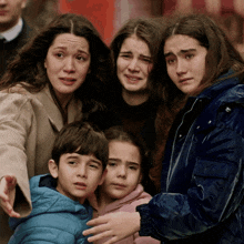 a group of people are standing next to each other and one of the girls is wearing a blue jacket