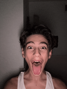 a young boy sticking his tongue out in a dark room