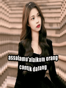 a woman in a black dress with the words assalamu ' alaikum orang cantik datang behind her