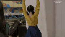 a woman in a yellow sweater stands in front of a bowling alley with a sign that says chr norma on it