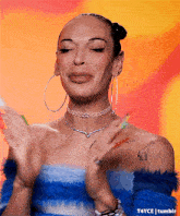 a woman wearing hoop earrings and a choker is making a funny face .