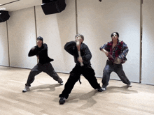 three people are dancing in a room with the word angels on the bottom left