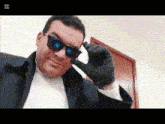 a man wearing sunglasses and a black glove is smiling