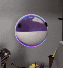 a purple and white ball is floating on a desk