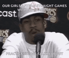 a man is talking into a microphone while wearing a hat .