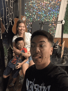 a man wearing a shirt that says ' vision ' on it poses with his family