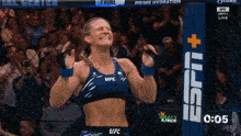 a woman in a blue ufc top is smiling
