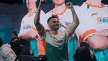 a man with his arms in the air wearing a shirt that says takor on it