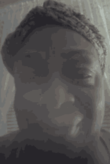 a blurry picture of a person 's face with a white curtain in the background