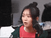 a woman is sitting in front of a microphone making a funny face .