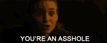 a close up of a woman 's face with the words `` you 're an asshole '' written on it .