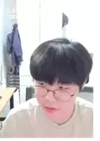 a man wearing glasses and a white shirt looks at the camera with the time 2:43