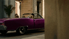 a purple car is parked in front of a building that says no parking