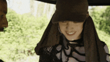 a woman wearing a hat and a scarf around her head