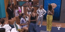 a group of women are standing in a room with a sign that says en vivo .
