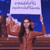 a woman with a flower in her hair is holding a sign that says ' thailand ' on it