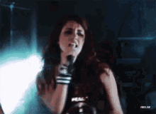 a woman singing into a microphone with rbd.gif written on the bottom right