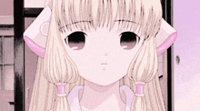 a close up of a girl with blonde hair and pigtails looking at the camera