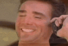 a close up of a man 's face with his eyes closed and a camera in his hand .