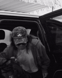 a black and white photo of a person getting out of a vehicle
