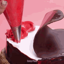 a cake is being decorated with red frosting and chocolate and the words easy plus are on the bottom