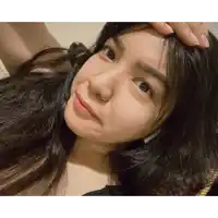 a woman with long black hair is taking a selfie with her hand on her forehead