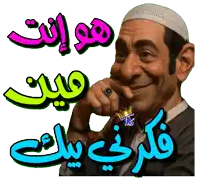 a man wearing a white hat is smiling with arabic writing on the bottom