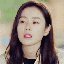 a close up of a woman 's face with a slight smile on her face .