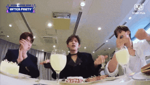 a group of men are sitting at a table with plates of food and wine glasses .