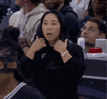 a woman wearing a guess watch sits in the stands