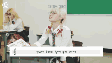 a girl wearing glasses is sitting at a desk in a classroom