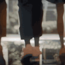 a blurry picture of a person 's legs standing next to a window