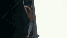 a shirtless man singing into a microphone while standing on a stage