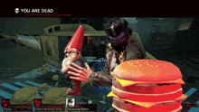 a screenshot of a video game shows a gnome holding a red cone and the words " you are dead "