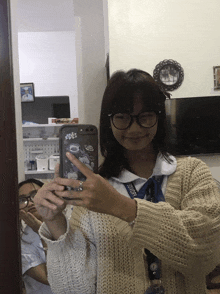 a girl taking a picture of herself in a mirror with a lanyard that says ' yamaha ' on it