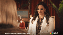 a woman in a white jacket is talking to another woman in a nbc ad