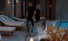 a man and a woman are walking by a pool