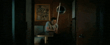 a man sitting at a table with a light saber in his hand
