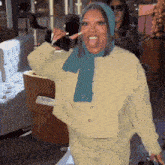 a woman wearing a yellow jacket and a blue scarf