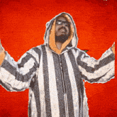 a man wearing a striped jacket with a hood and sunglasses