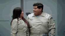 a man and a woman are standing next to each other and the man has a sticker on his jacket that says ' space '