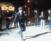 a man in a black shirt is dancing in front of a crowd of people