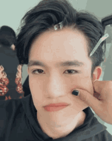 a close up of a man 's face with a person 's hand pressing his cheek