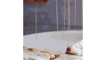 a pizza is being cut into slices and cheese is being poured on top of it .