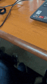 a msi laptop sits on a wooden desk next to a cord