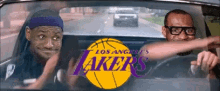 two men in a car with a lakers logo